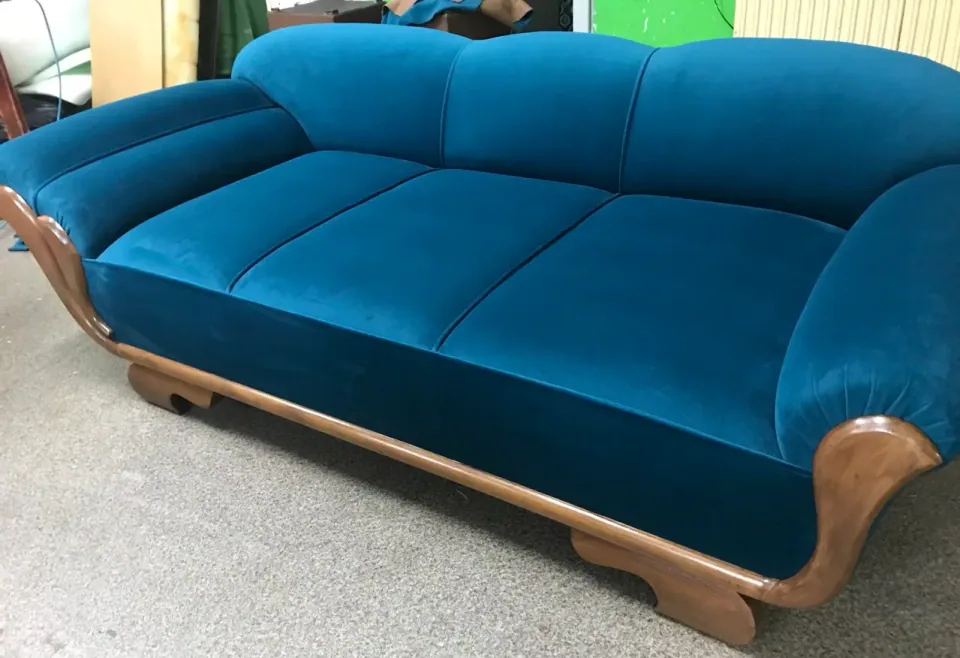 Odnowiona sofa z niebieską welurową tapicerką