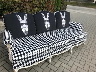 Sofa w czarno-białą pepitkę z poduszkami w jelenie