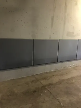 Szare panele ochronne zamontowane na ścianie garażu