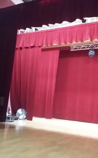 Czerwona kurtyna sceniczna z dekoracyjnym lambrekinem