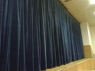 Granatowa kurtyna sceniczna rozwieszona w sali